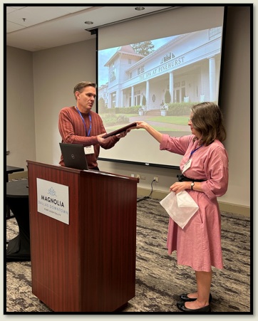 Brett McInelly receives his award from Susan Spencer